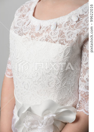 girl wearing festive white dress as braidmaid or flower girl. unrecognizable kid. lace fabric for party dress girl wearing festive white dress as braidmaid or flower girl. unrecognizable kid. lace fabric for party dress 99622016