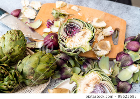 Top view of Sliced artichoke and kitchen knife on on wooden cutting board on table. Flat lay of Healthy food vegetables. 99623685
