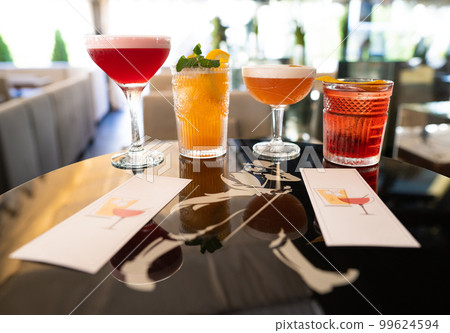 beautiful and delicious alcoholic cocktails prepared at the bar by the bartender. 99624594