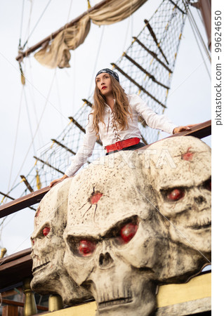 a beautiful girl in a pirate costume on the deck of a ship. a beautiful girl in a pirate costume on the deck of a ship. 99624650