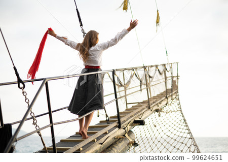 a beautiful girl in a pirate costume on the deck of a ship. a beautiful girl in a pirate costume on the deck of a ship. 99624651