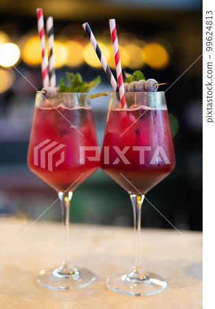 beautiful and delicious alcoholic cocktails prepared at the bar by the bartender. 99624813