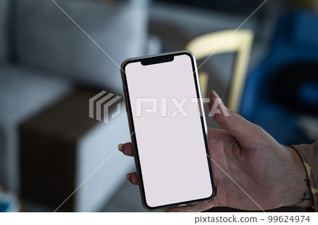 smartphone with a white screen in a woman's hand.  99624974