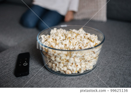 Preparing for watching movie at home. Close-up of popcorn on sofa 99625136