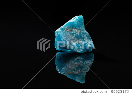 Raw Blue Apatite Uncut Gem Stone on Black Surface 99625173