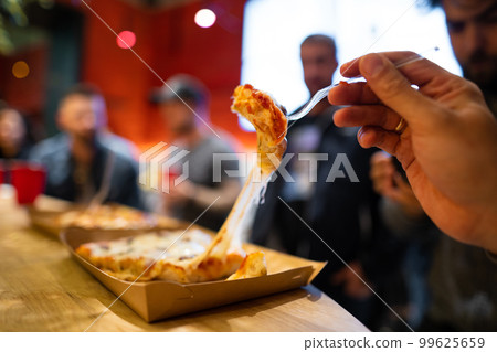 a piece of pizza with melted cheese that stretches 99625659