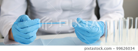 Gynecologist in gloves holds brush and gynecological glass 99626034