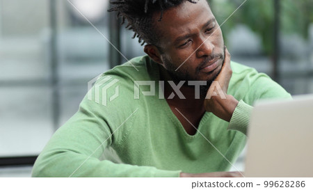 Business man in casual clothes thinking behind a laptop 99628286