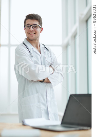 handsome young doctor portrait in medical office handsome young doctor portrait in medical office 99628333