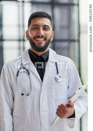Smiling male doctor with arms crossed in hospital 99628540
