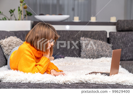 child uses a laptop at home for online learning and entertainment 99629400