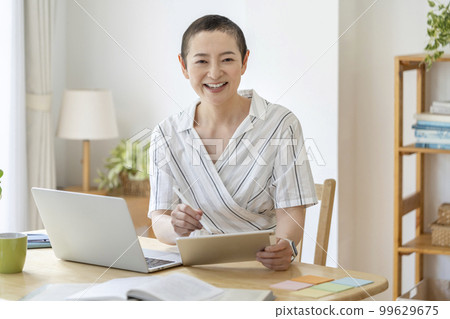 Middle-aged women working from home, balancing cancer treatment and work Middle-aged women working from home, balancing cancer treatment and work 99629675