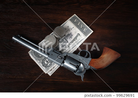 Old west revolver with bill and silver dollars Old west revolver with bill and silver dollars 99629691