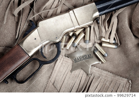Old west period repeating rifle with ammunition and marshal badge Old west period repeating rifle with ammunition and marshal badge 99629714