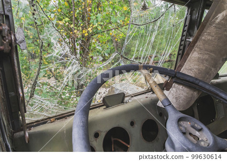 Broken windshield in an old abandoned car 99630614
