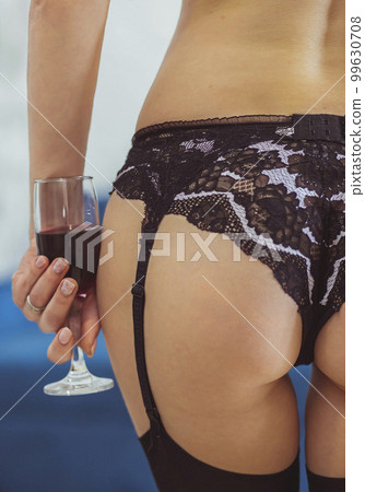 Sexy woman in stockings and lingerie holding a glass of wine 99630708