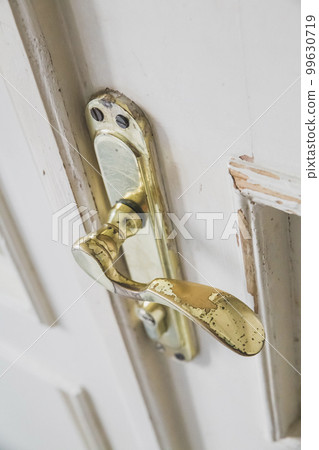 Old shabby doorknob in a white door Old shabby doorknob in a white door 99630719