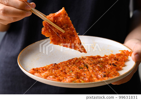 Kimchi pancake (Kimchi jeon or kimchi buchimgae) with hand ready to eating, Korean food Kimchi pancake (Kimchi jeon or kimchi buchimgae) with hand ready to eating, Korean food 99631831