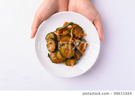 Kimchi cucumber with hand on white background, Korean food homemade side dish, Top view 99631884