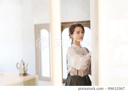 woman putting dishes in the cupboard 99632067