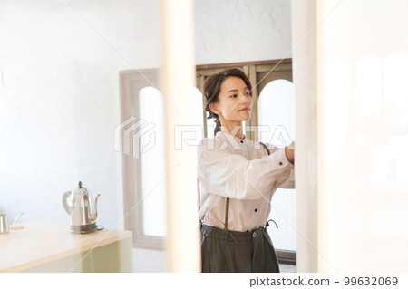 woman putting dishes in the cupboard 99632069