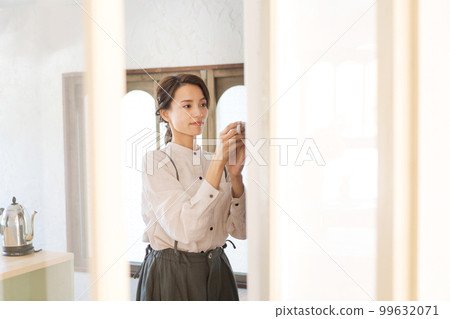 woman putting dishes in the cupboard woman putting dishes in the cupboard 99632071