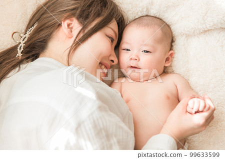 A baby relaxing on a futon and a postpartum mom (parent and child, childbirth, mother and child, postpartum, puerperal period) A baby relaxing on a futon and a postpartum mom (parent and child, childbirth, mother and child, postpartum, puerperal period) 99633599