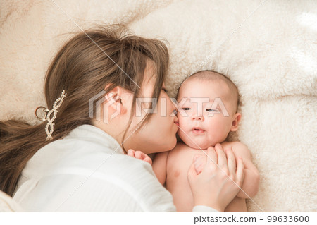 A baby relaxing on a futon and a postpartum mom (parent and child, childbirth, mother and child, postpartum, puerperal period) A baby relaxing on a futon and a postpartum mom (parent and child, childbirth, mother and child, postpartum, puerperal period) 99633600