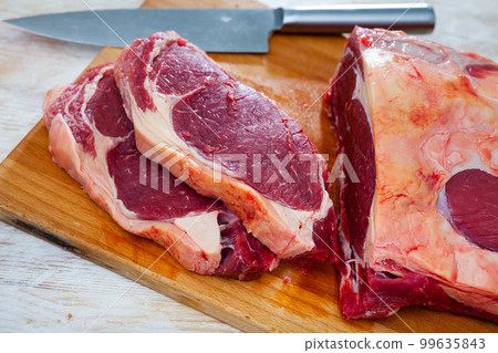 Pieces of raw boneless beef tenderloin on wooden background Pieces of raw boneless beef tenderloin on wooden background 99635843