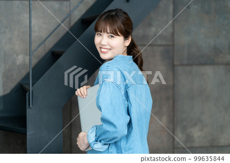 帶著筆記本電腦轉身的休閒女性 帶著筆記本電腦轉身的休閒女性 99635844