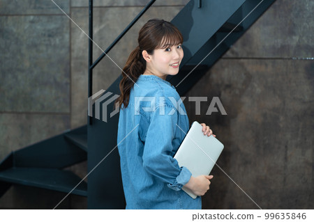 帶著筆記本電腦轉身的休閒女性 帶著筆記本電腦轉身的休閒女性 99635846