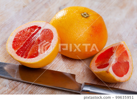 Whole and half fresh yellow pomelo on wooden table. Whole and half fresh yellow pomelo on wooden table. 99635951