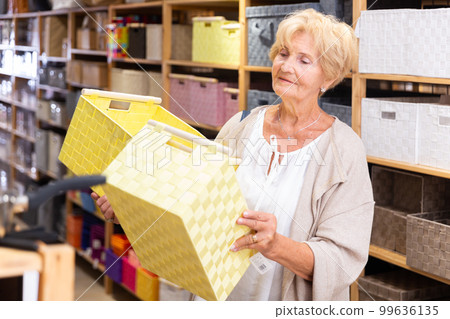 Mature woman buying storage basket 99636135