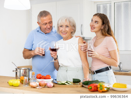 Happy family of three preparing lunch together in modern kitchen Happy family of three preparing lunch together in modern kitchen 99636364