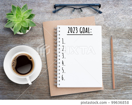 2023 goal on blank open book mock up on wood table background. 99636858