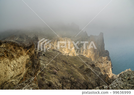 Dead city in fog and clouds. Khoba-Tele Ridge of Karadag Reserve in spring. Crimea 99636999