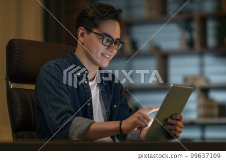 Smiling young man holding using digital tablet pc at office 99637109