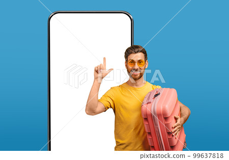 Happy male tourist pointing finger up at smartphone with mockup 99637818