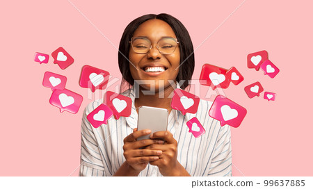 Happy young african american woman has romantic chat with hearts on phone, enjoys message, good news Happy young african american woman has romantic chat with hearts on phone, enjoys message, good news 99637885
