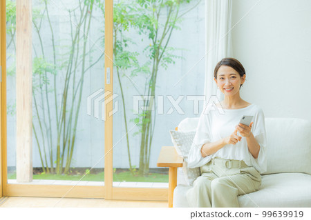 在客廳智能手機的女人 在客廳智能手機的女人 99639919