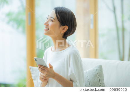 Woman in the living room Smartphone Woman in the living room Smartphone 99639920