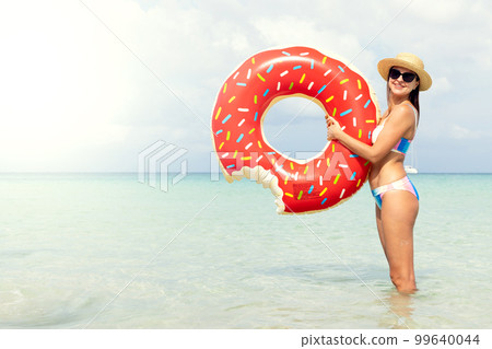 Beautiful woman with inflatable donut Beautiful woman with inflatable donut 99640044
