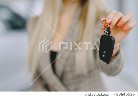 Lady in a car salon. Woman buying the car. Elegant woman in a brown suit. 99640589