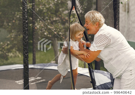 Family in a back yeard. Granddaughter with grandmother. 99640642
