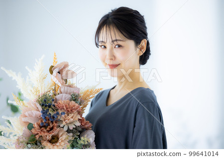 A woman holding a bouquet 99641014