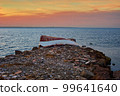 Old abandoned damaged fishing boat laying on the stone pier 99641640