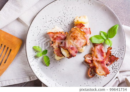 Mashed potatoes wrapped in fried bacon on a plate on the table. Top view. Closeup Mashed potatoes wrapped in fried bacon on a plate on the table. Top view. Closeup 99641734