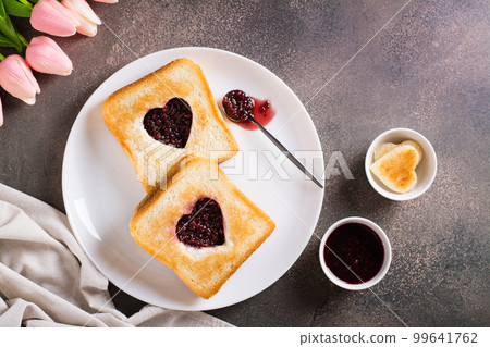 Heart shaped toast with raspberry jam on a plate. Food for lovers. Top view 99641762