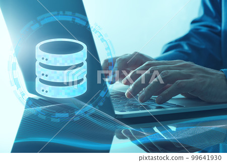 An image that builds and uses a database. Close up of a hand using a database icon and a laptop. 99641930