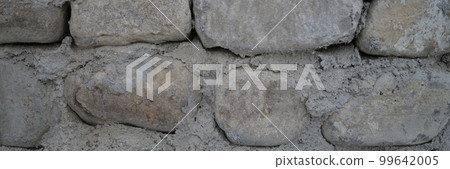 Old castle stone wall texture background. Finishing the facade with stone Old castle stone wall texture background. Finishing the facade with stone 99642005